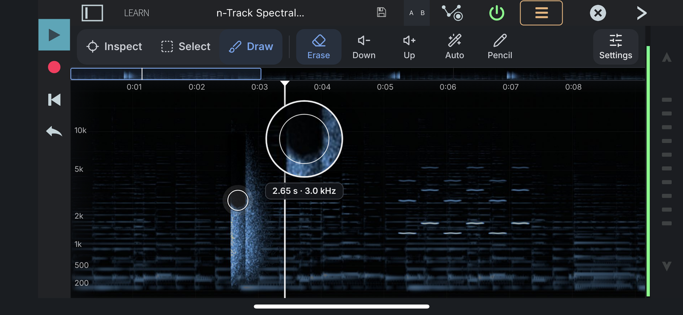 Draw mode with the Erase tool, a magnifier above the finger showing the sound being removed